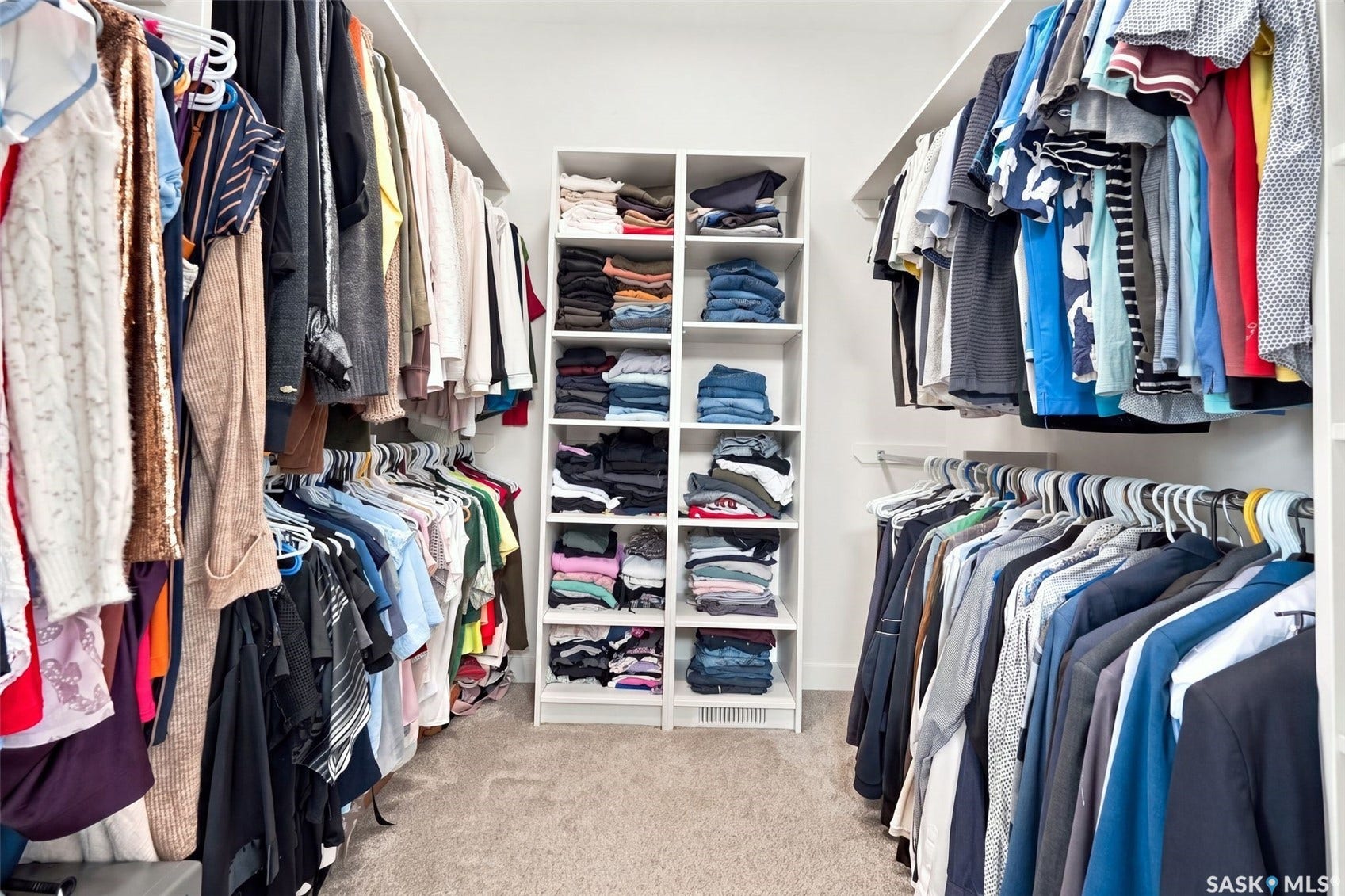 6221 Koep Avenue, Regina SK S4X 0J2 Built-in closet system featuring multiple hanging rods, integrated shelving units, and carpet flooring
