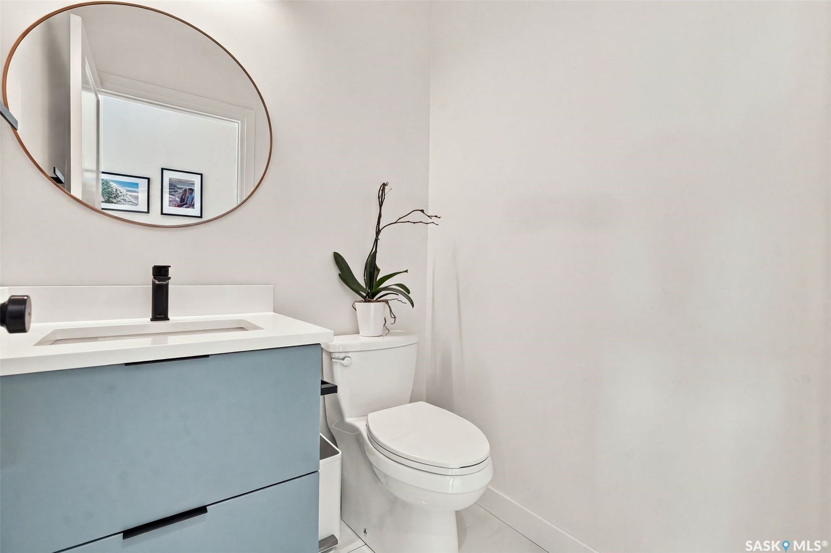 6221 Koep Avenue, Regina SK S4X 0J2 Integrated white vanity sink with a light-toned countertop, matte black faucet, and modern blue-grey cabinetry