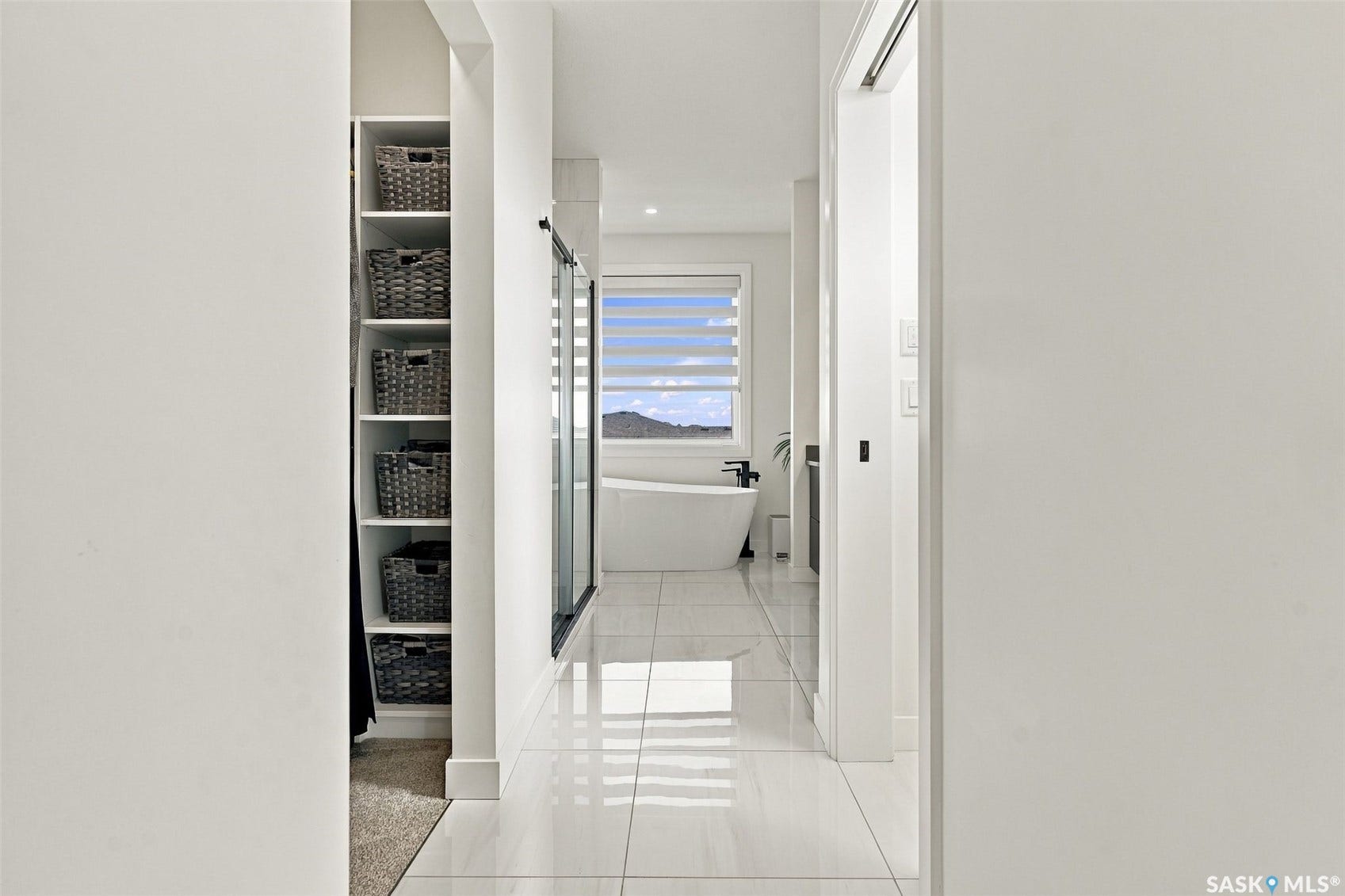 6221 Koep Avenue, Regina SK S4X 0J2 Built-in shelving, sliding barn door, tiled flooring, freestanding bathtub, and a modern window