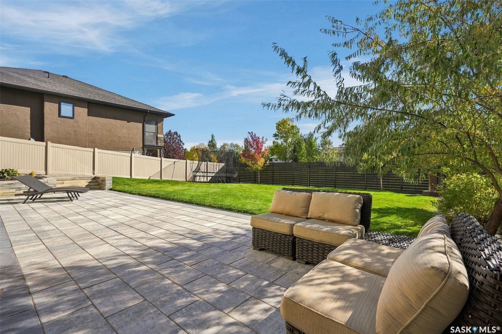 6221 Koep Avenue, Regina SK S4X 0J2 Expansive paver patio with a manicured lawn and mature trees
