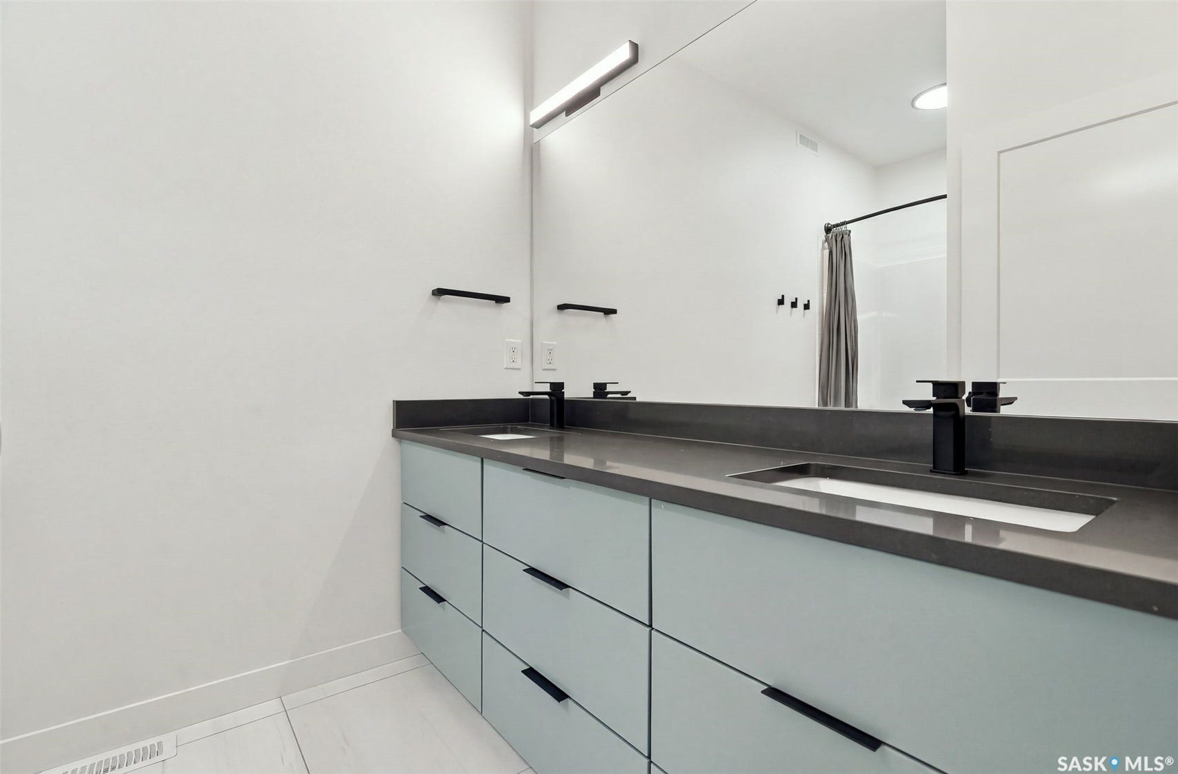 6221 Koep Avenue, Regina SK S4X 0J2 Dual vanity with light blue cabinetry, matte black hardware, and integrated rectangular sinks
