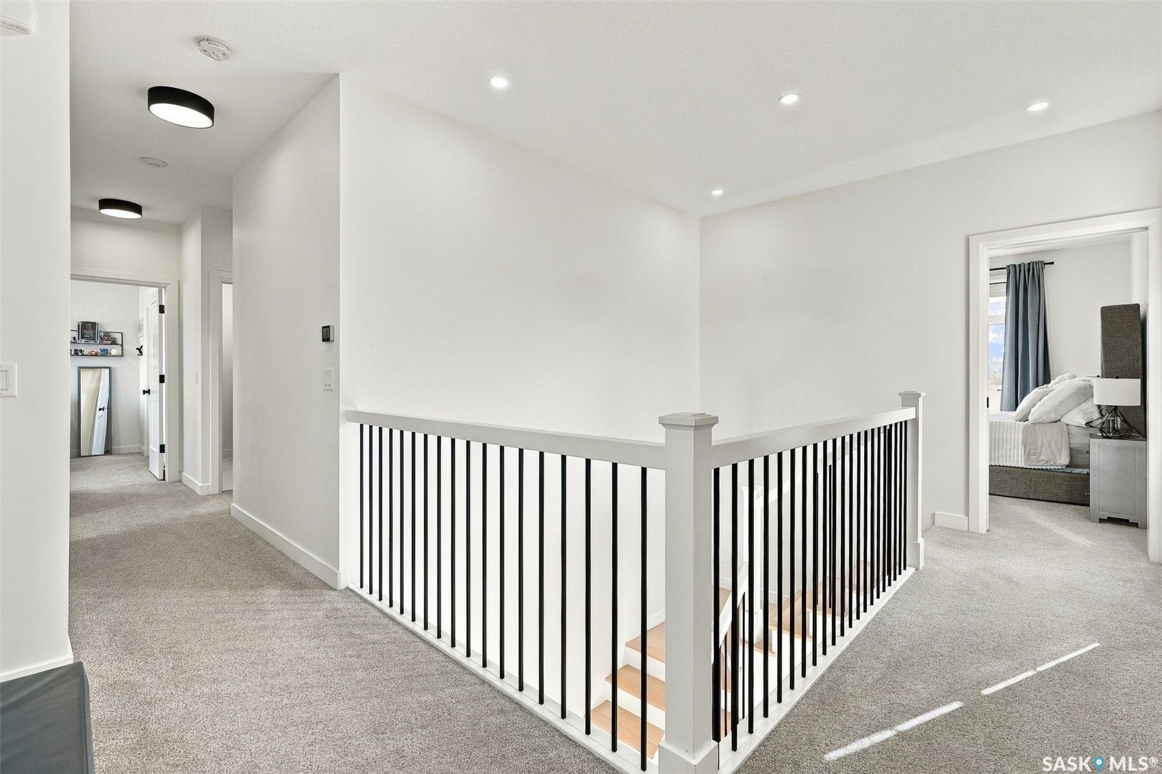 6221 Koep Avenue, Regina SK S4X 0J2 Carpeted hallway with recessed lighting and a staircase featuring wood treads and metal balusters