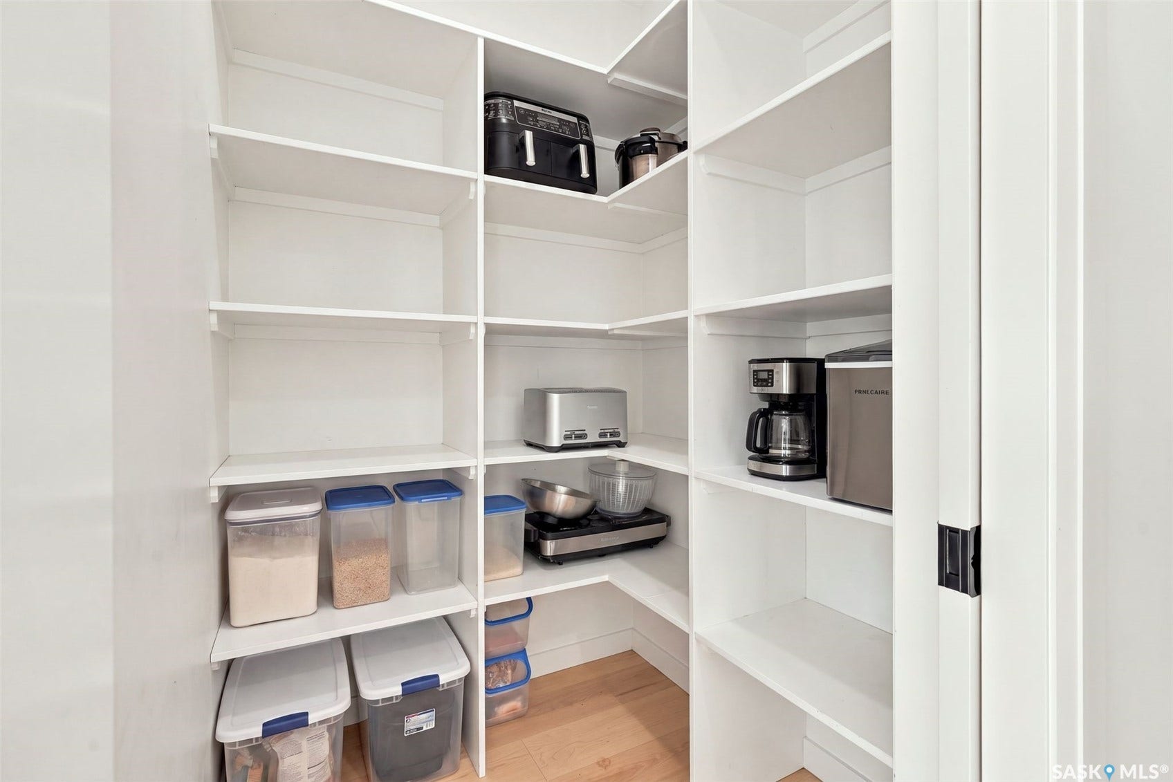 6221 Koep Avenue, Regina SK S4X 0J2 Built-in pantry shelving with white finishes and wood-finish flooring