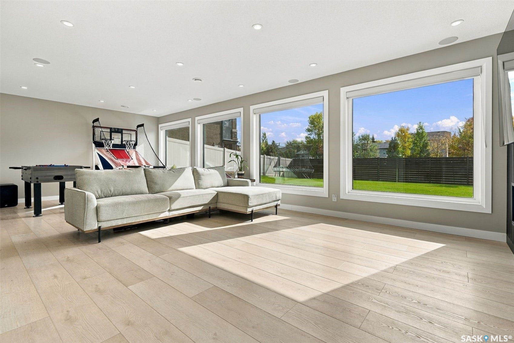 6221 Koep Avenue, Regina SK S4X 0J2 Recessed lighting, wood-finish flooring, and multiple large windows with white trim