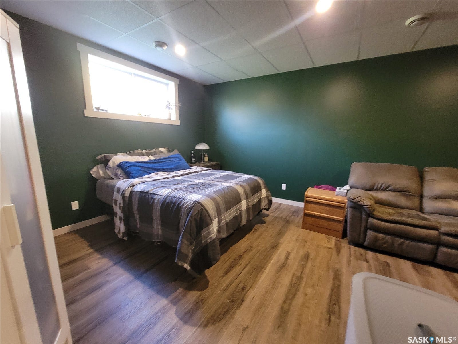 Wood-finish flooring, recessed lighting, drop ceiling, and a single window with white trim
