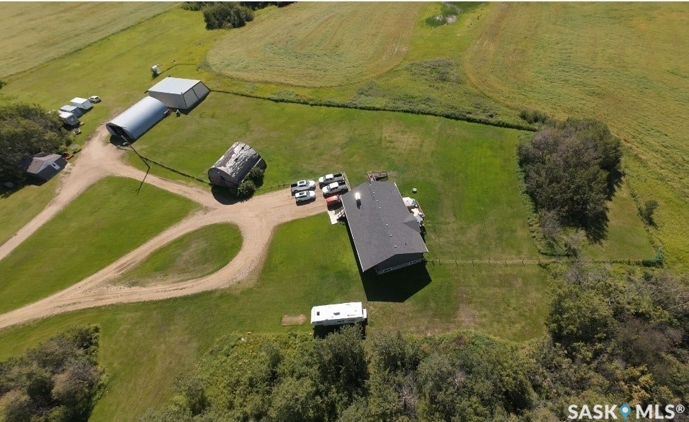 Expansive property featuring an asphalt shingle roof, multiple outbuildings, and a gravel driveway