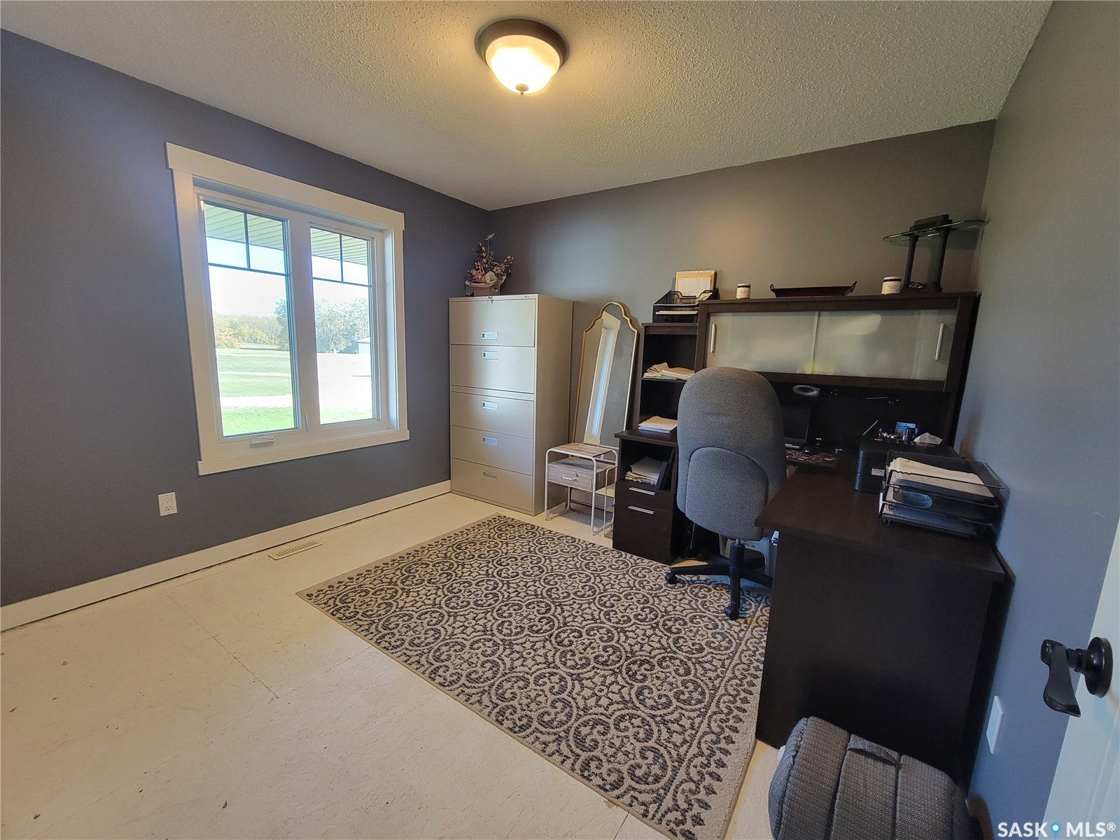 Neutral color palette with white window trim and ceiling, featuring a window with exterior visibility and wall-mounted lighting