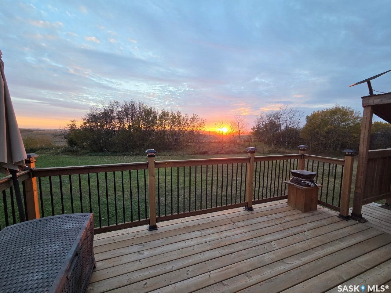 Spacious outdoor deck with wood flooring and dark railing