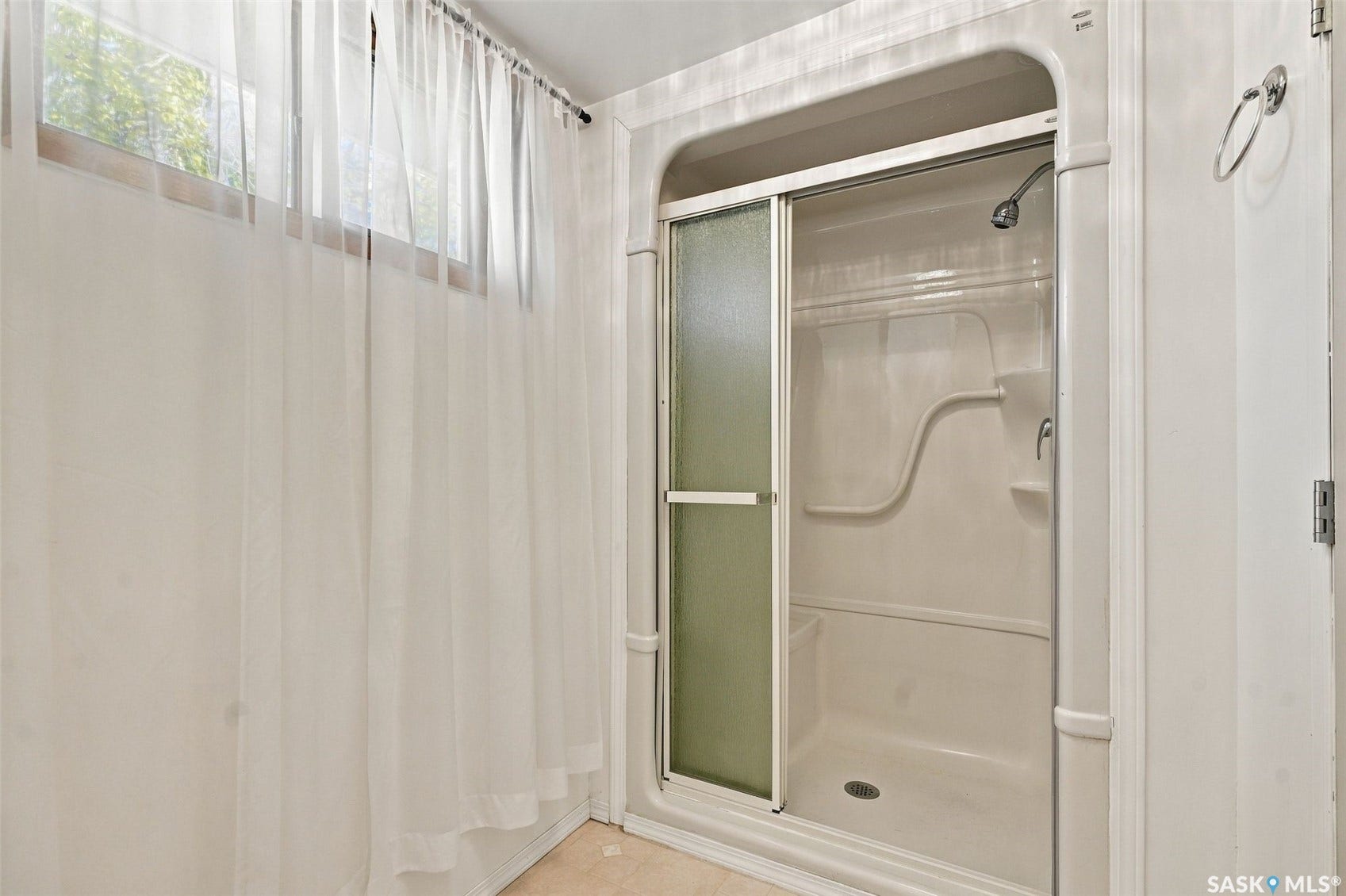 Walk-in shower with sliding glass doors and an integrated showerhead