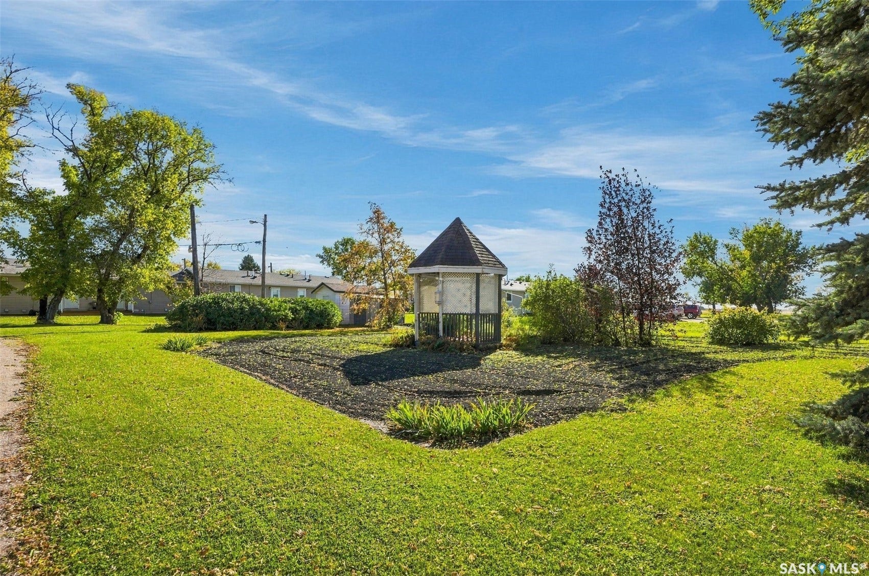 Expansive green lawn with mature trees and a charming gazebo