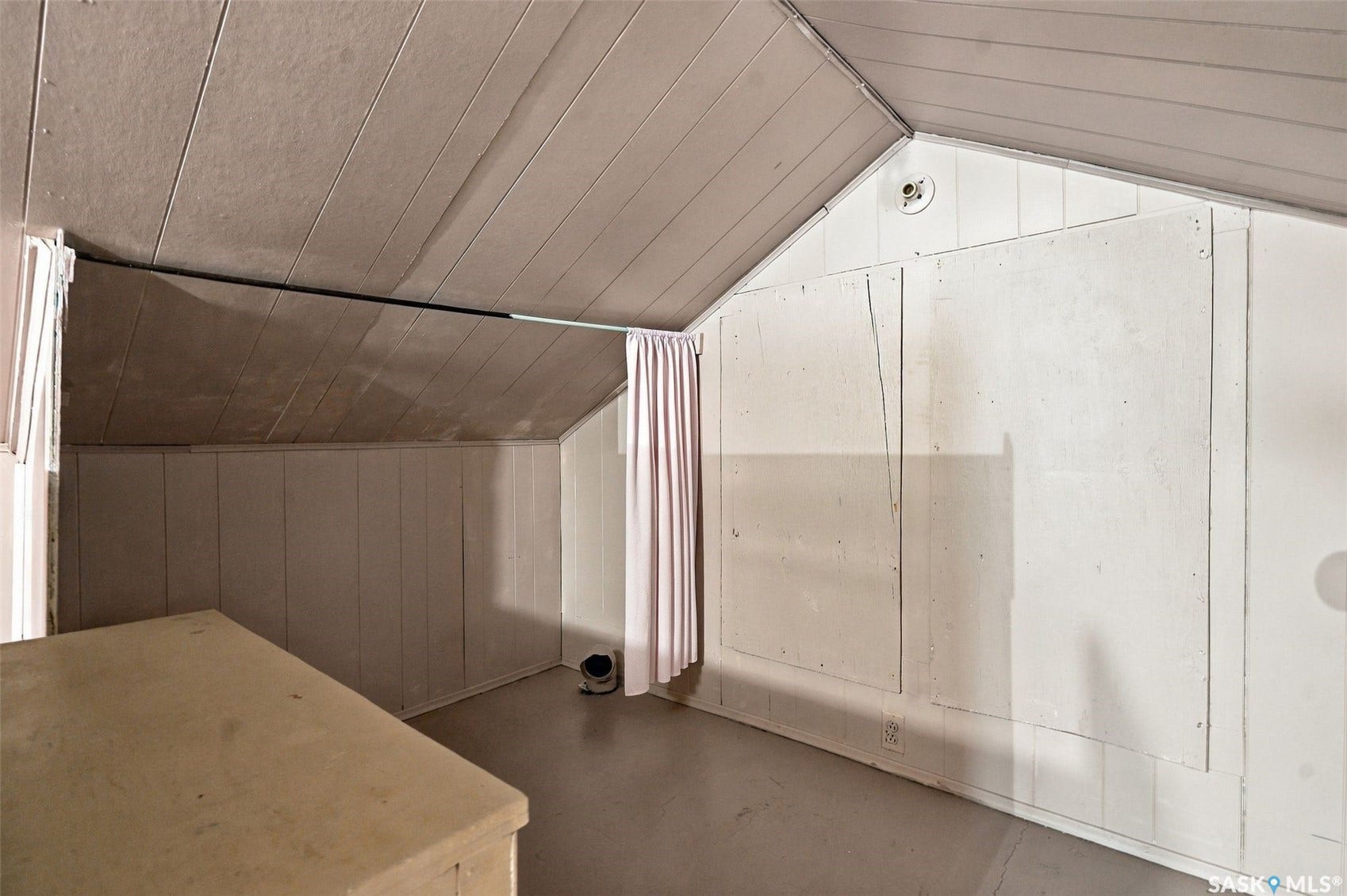 Sloped ceiling with paneling, paneled walls, and built-in storage access