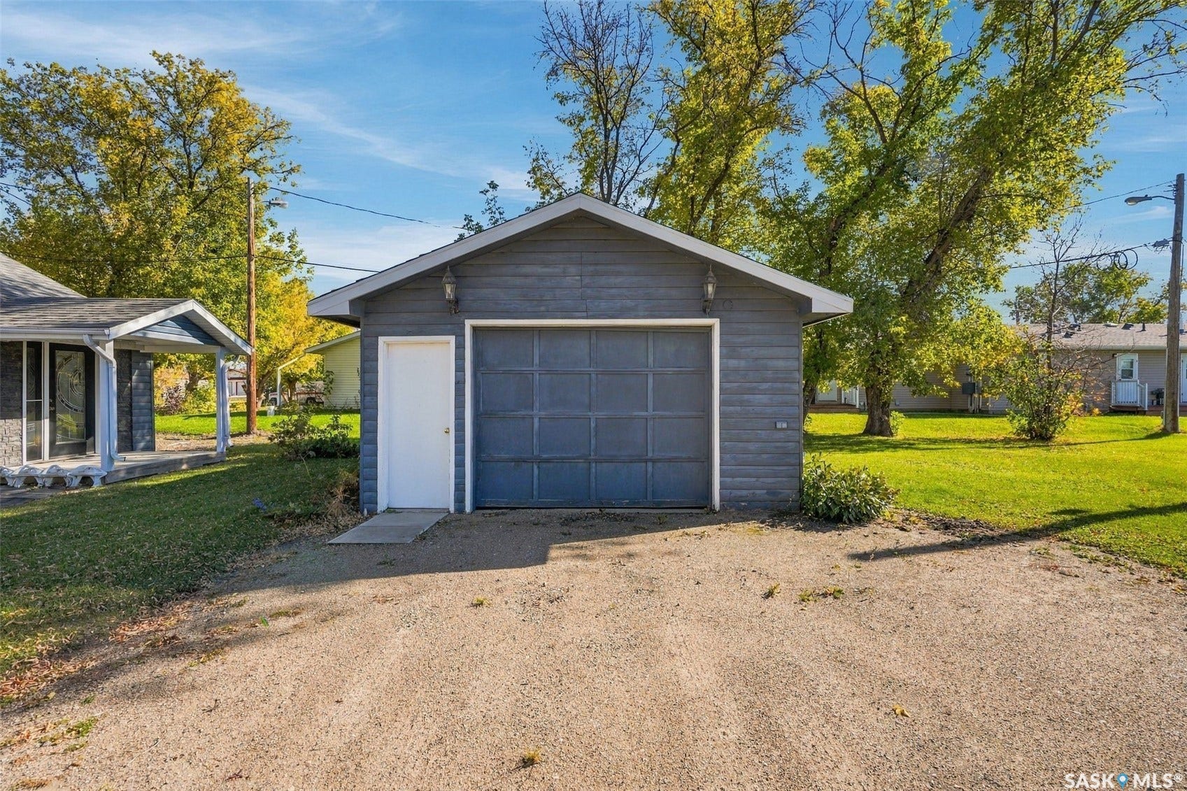 Detached garage with horizontal siding, a single-car garage door, and a dedicated side entry door