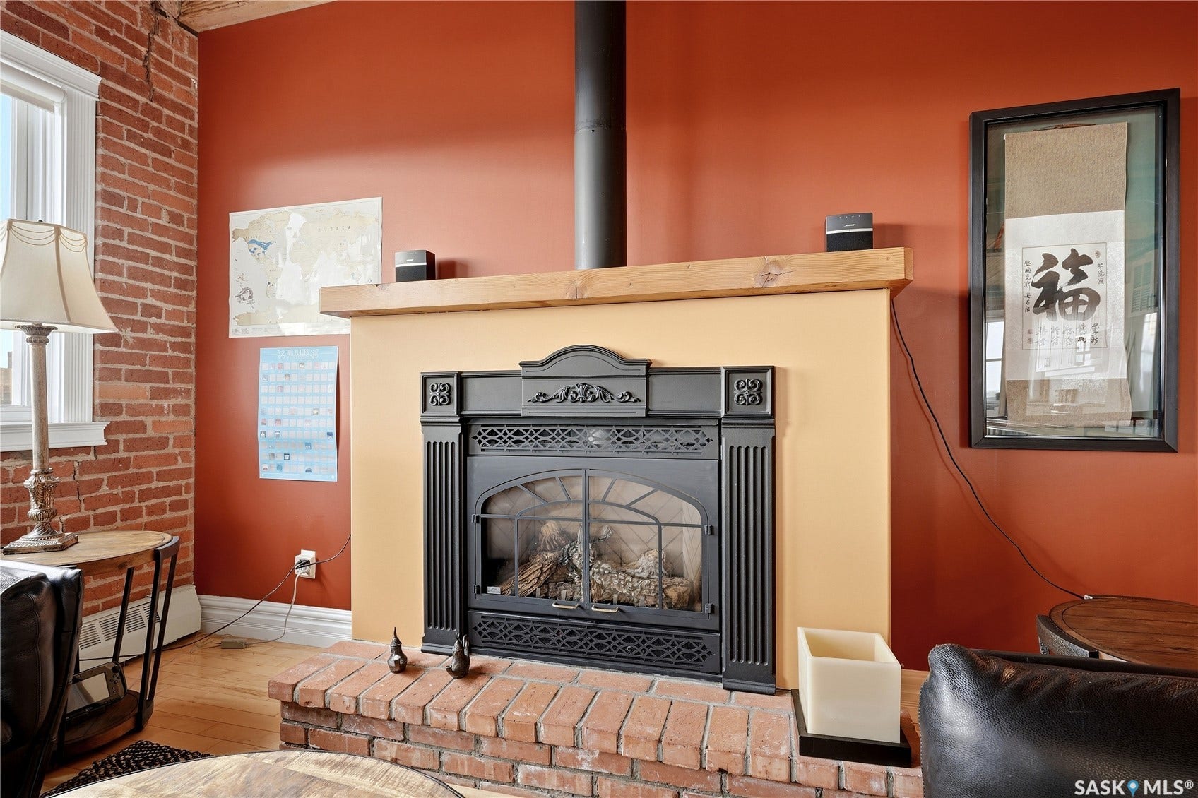 Brick-clad wood-burning fireplace with a contrasting mantel and hearth