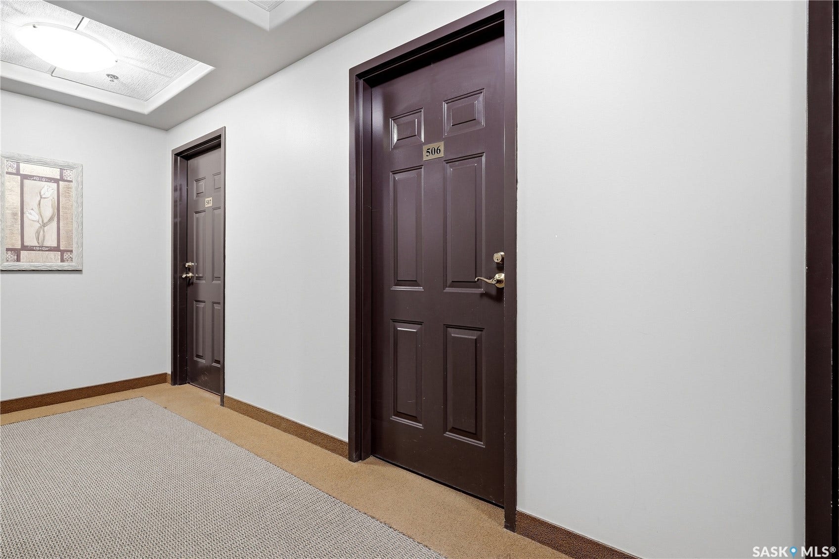 Recessed lighting fixture, paneled doors with brass hardware, and light-toned carpeting