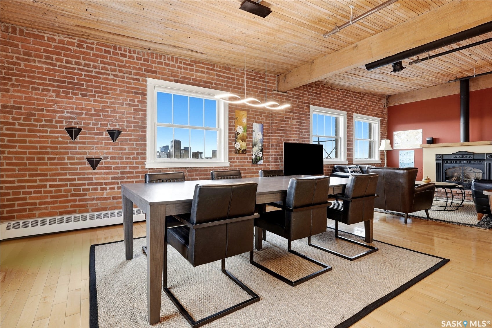 Exposed brick walls, wood-finish flooring, wood plank ceiling, exposed wood beams, and a built-in fireplace with mantle