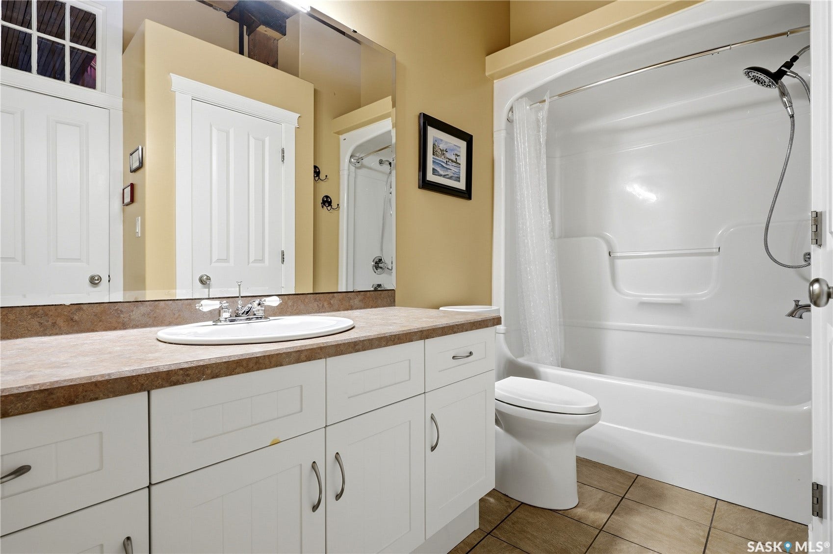 Vanity with an integrated sink and chrome faucet, white cabinetry, and a textured countertop