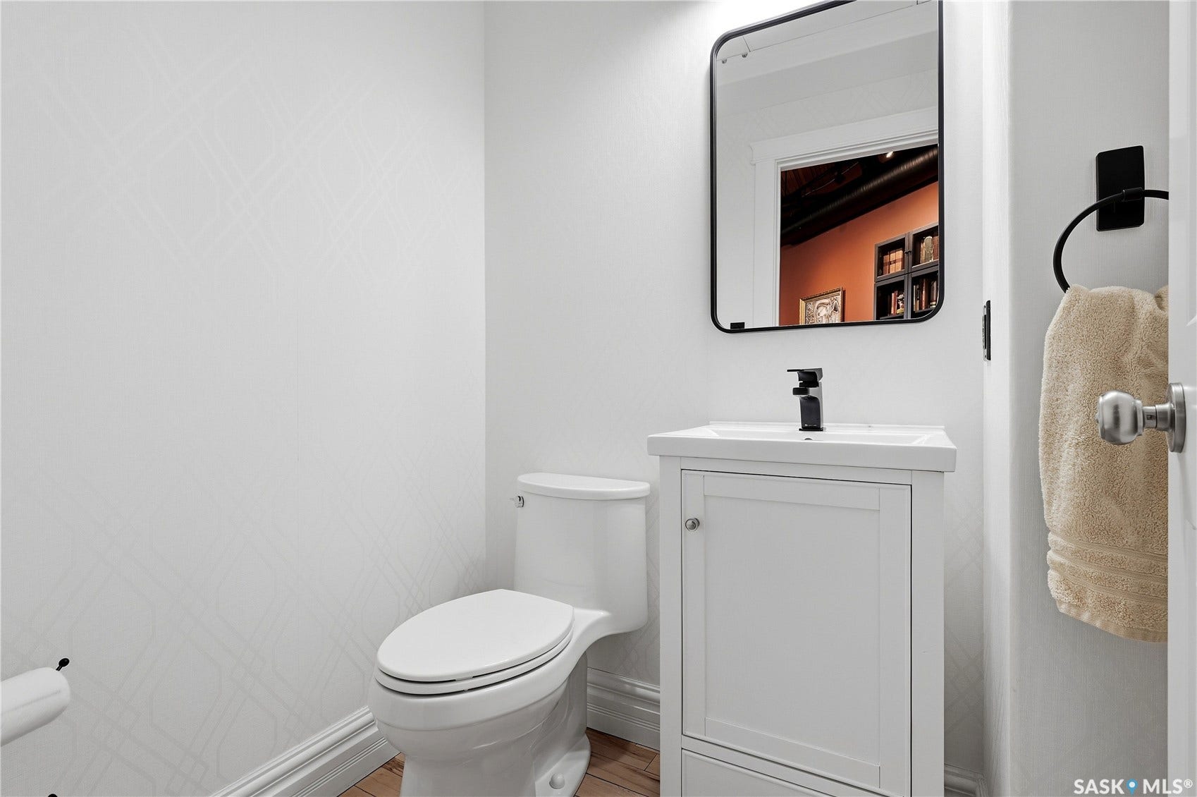 White vanity with integrated sink, matte black faucet, and rectangular mirror