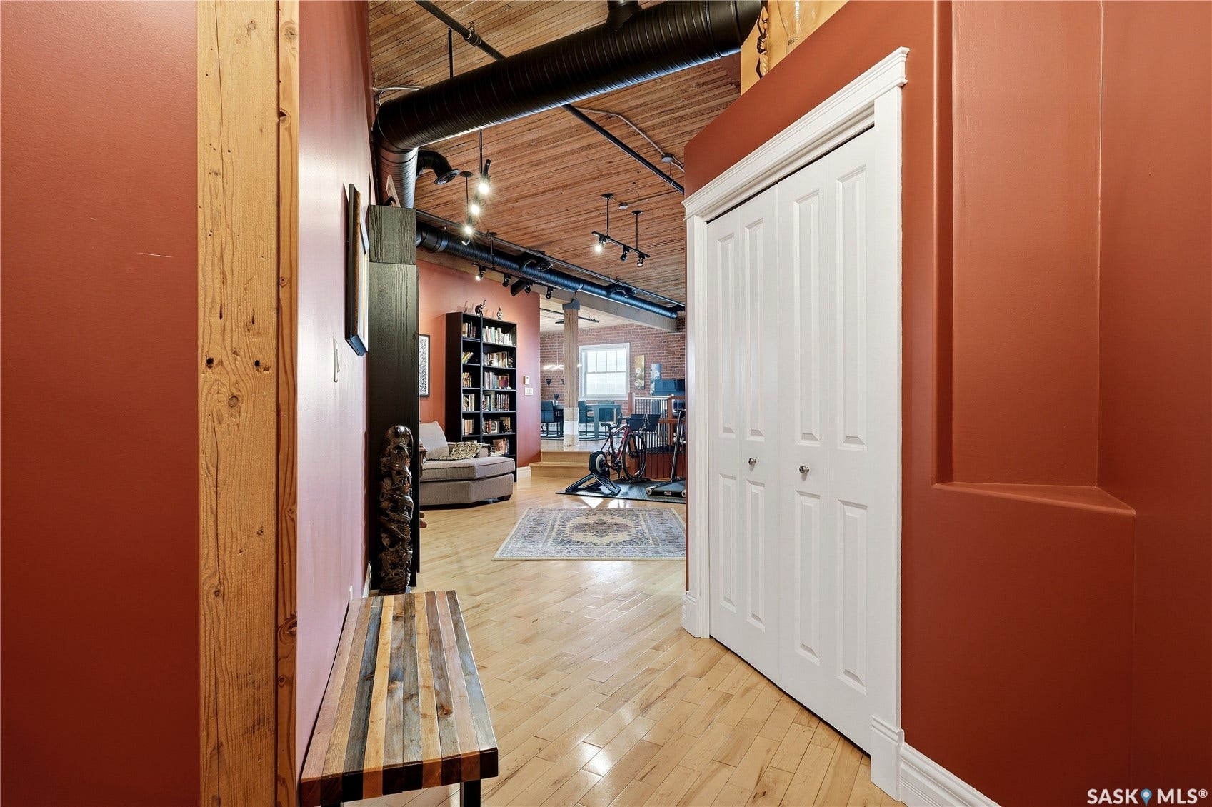 Exposed ductwork, track lighting, and wood-finish flooring