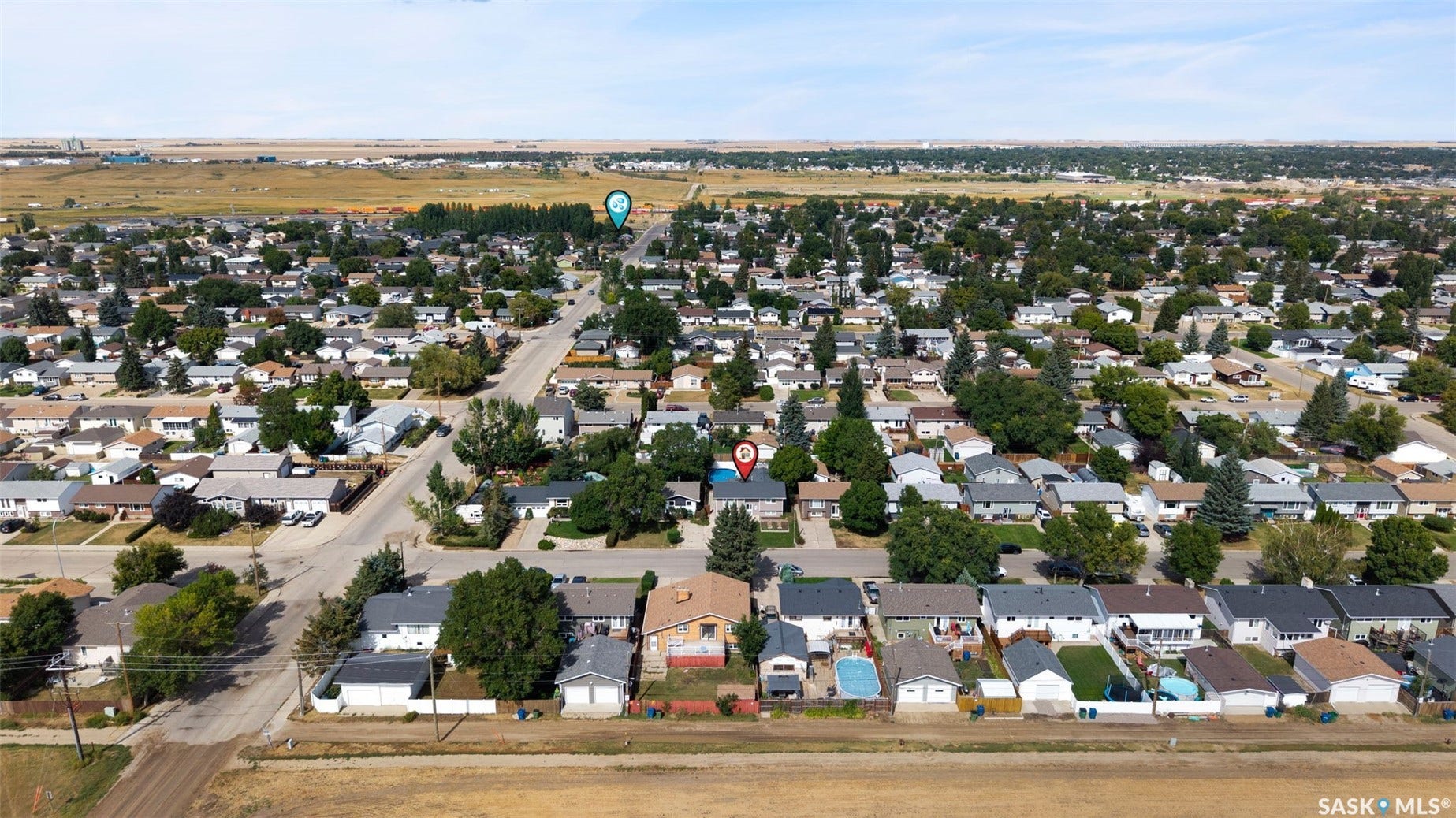 Aerial perspective showcasing a residential neighborhood with varied home designs, established landscaping, and a distant natural landscape