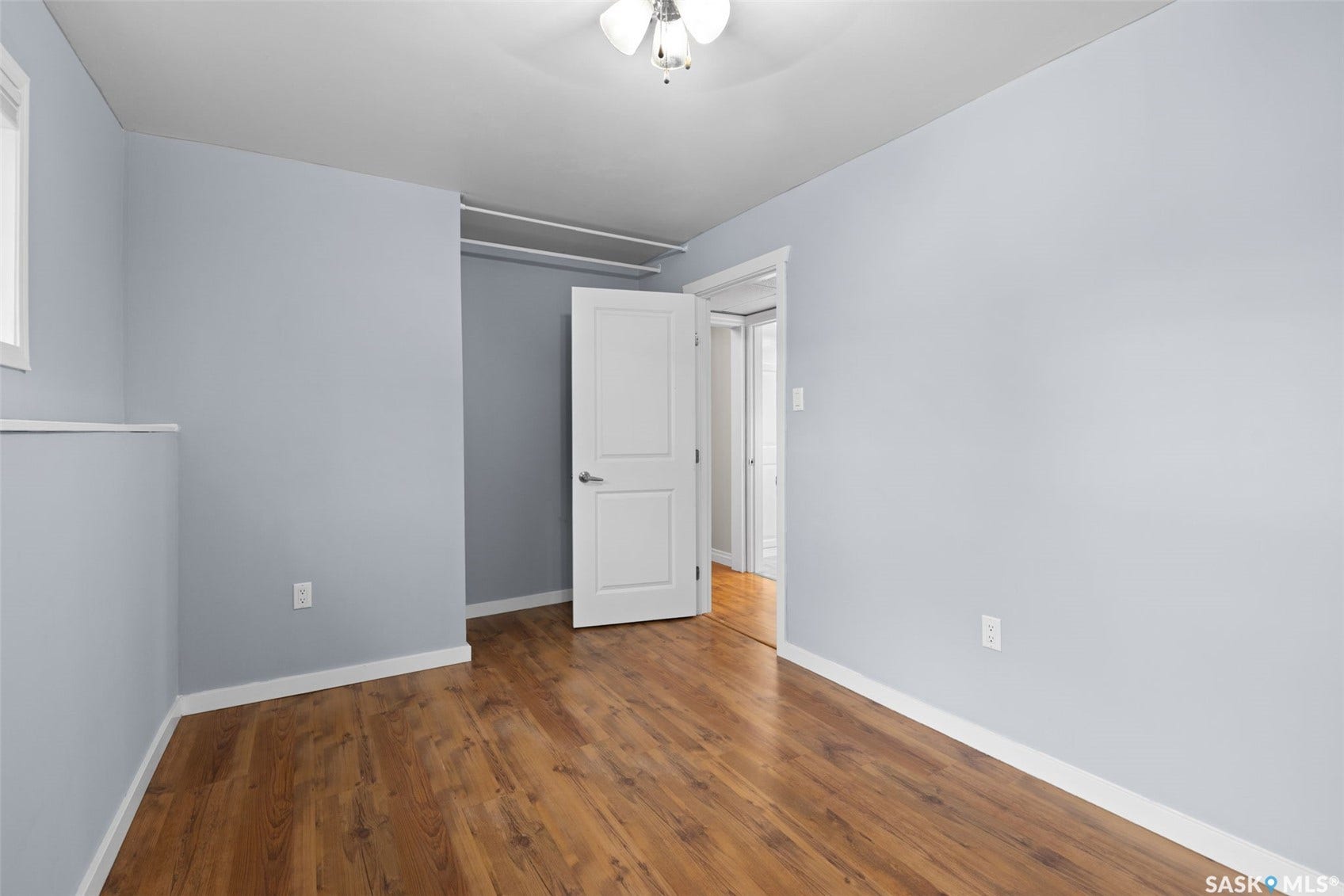 Room featuring wood-finish flooring, light blue walls, and a white ceiling