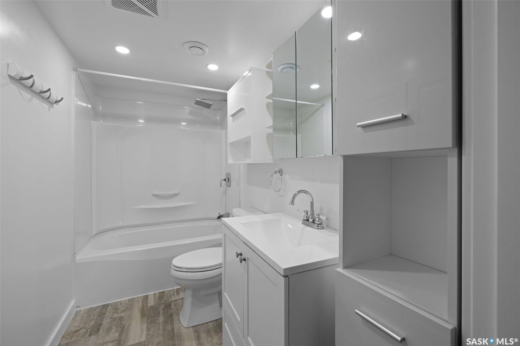 Contemporary bathroom featuring recessed lighting, a built-in shower/tub combination, a vanity with an integrated sink, and wood-finish flooring