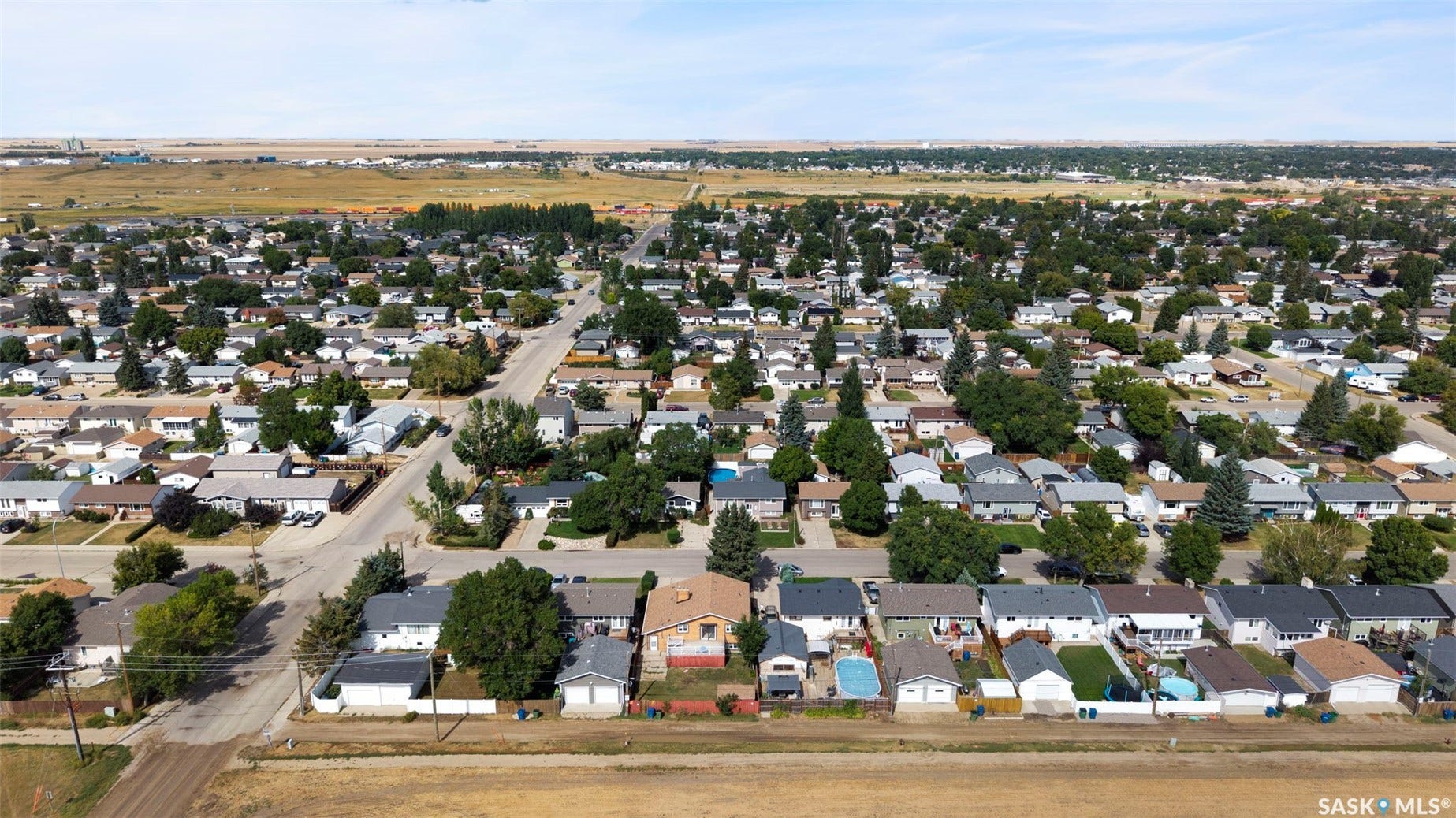 Residential area featuring numerous single-story homes, mature trees, and paved streets