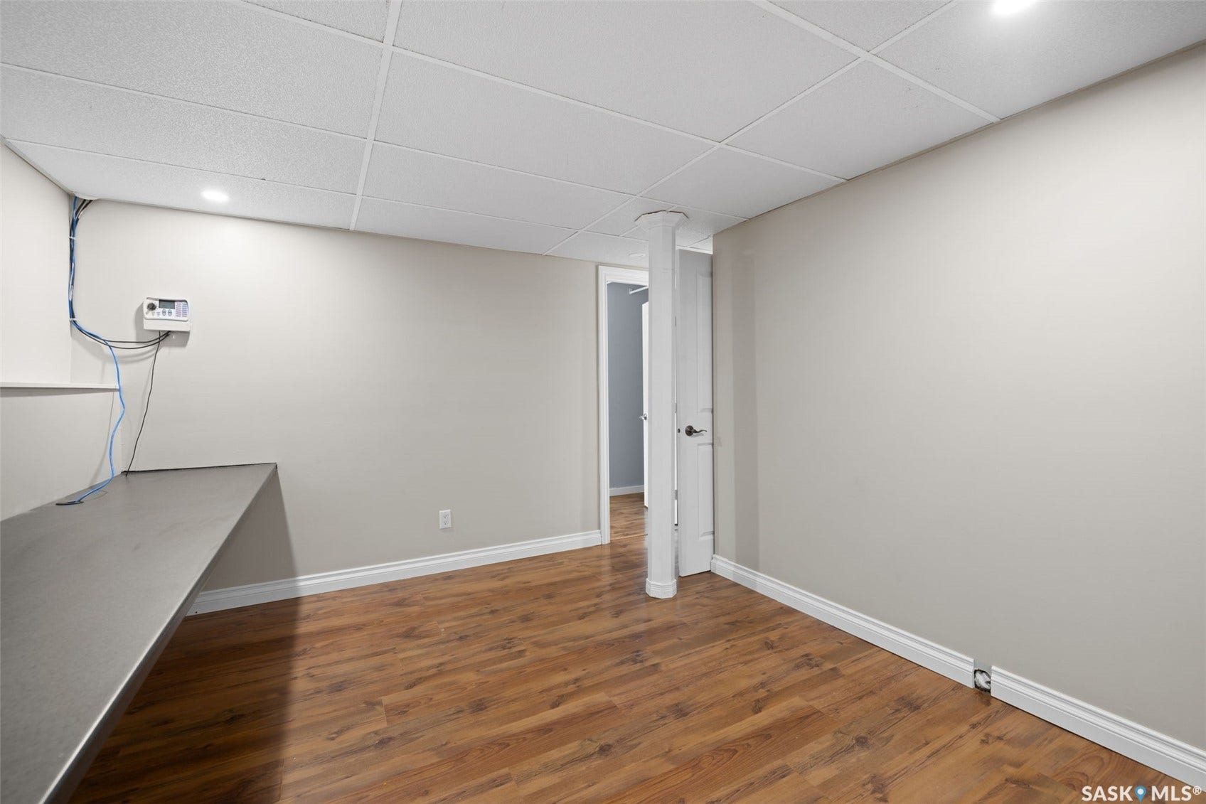Recessed lighting, wood-finish flooring, drop ceiling, neutral wall paint, and white trim