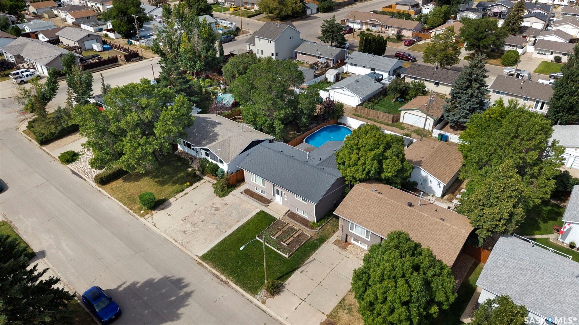 Single-story property with a gray facade, adjacent detached garage, and an in-ground swimming pool