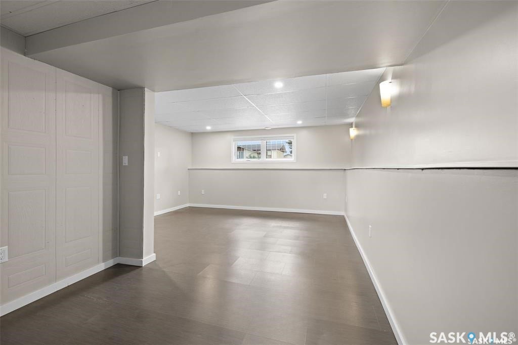 Spacious room featuring dark wood-finish flooring, recessed lighting, and a white drop ceiling