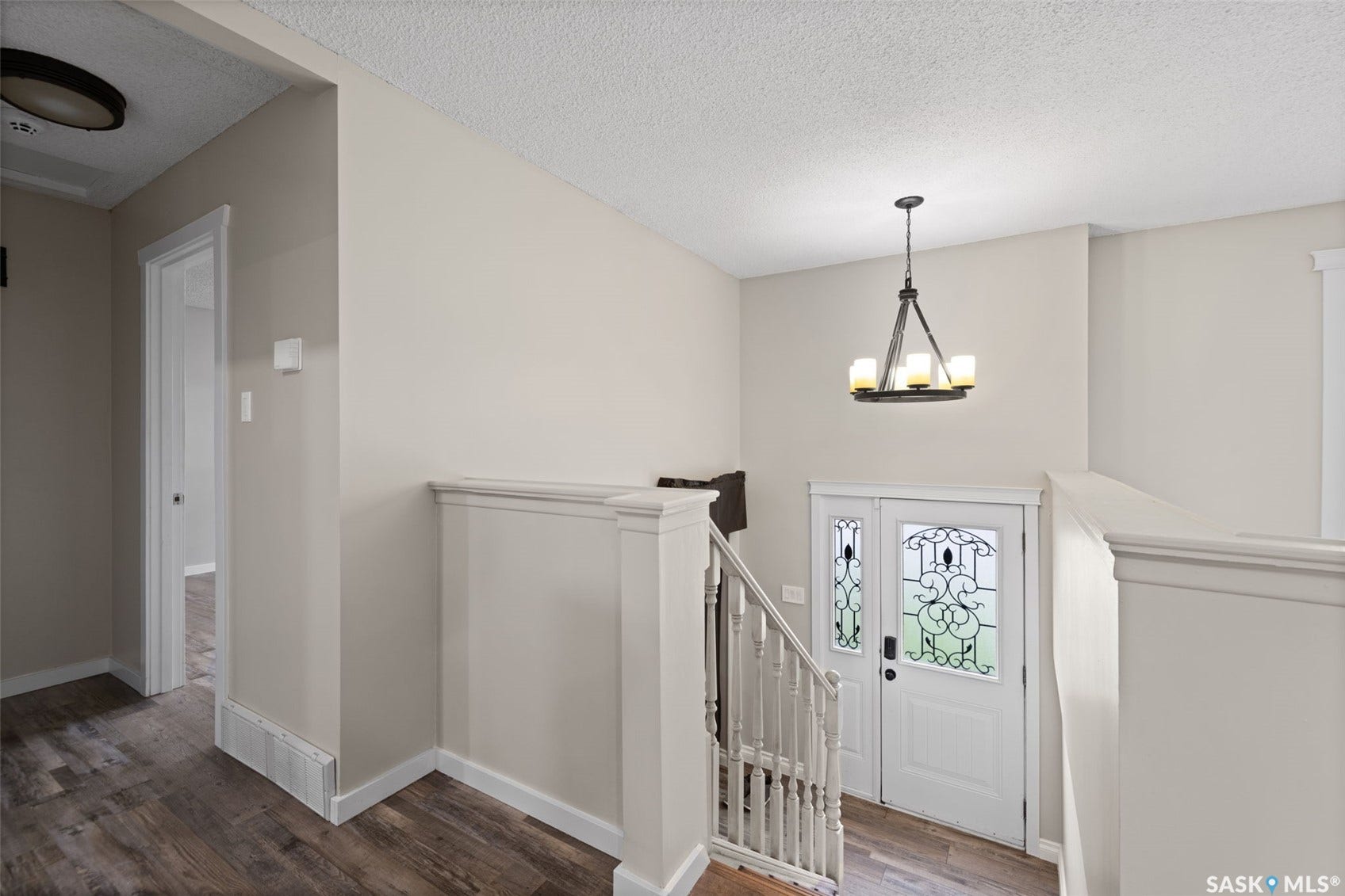 Entryway featuring a decorative double-door, wood-finish flooring, and a wrought iron chandelier