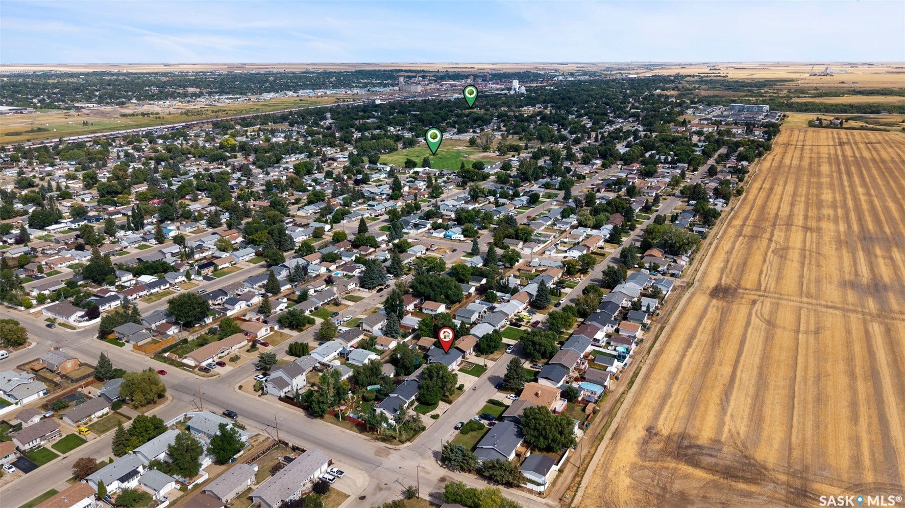Aerial perspective showcasing a residential neighborhood bordering cultivated fields