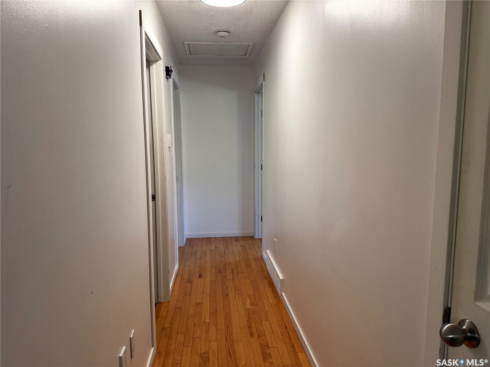 708 Studer Street, La Ronge SK S0J 1L0 Hallway featuring wood-finish flooring, white walls, and recessed lighting