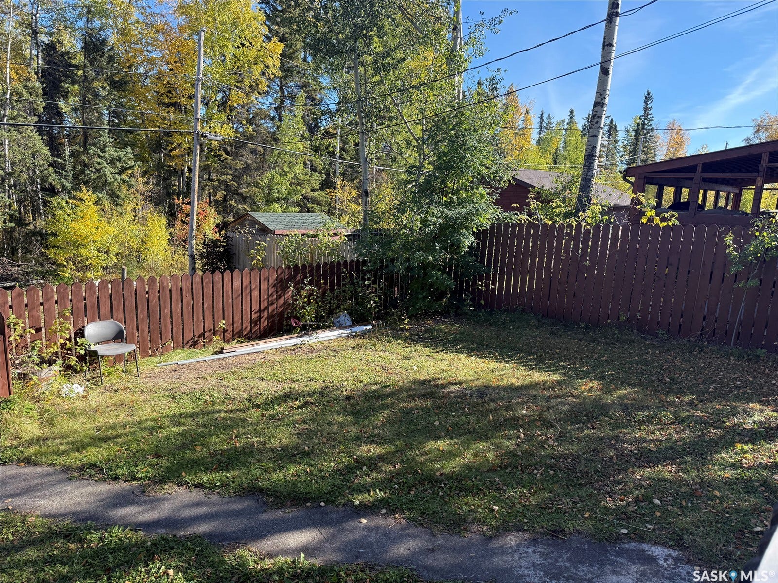 708 Studer Street, La Ronge SK S0J 1L0 Fenced yard with a storage shed and mature trees