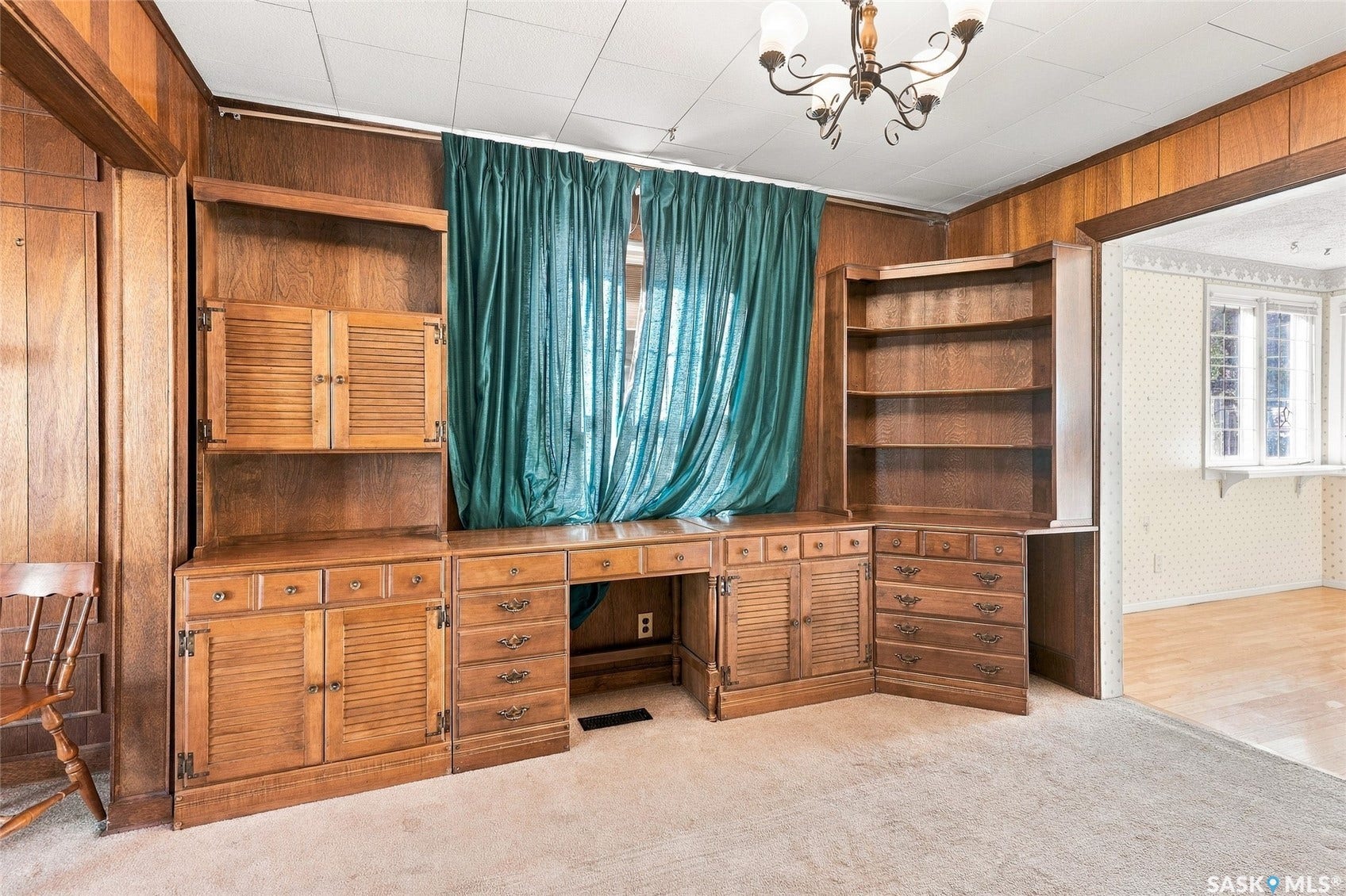 Built-in wood cabinetry with louvered doors, integrated shelving, and desk space