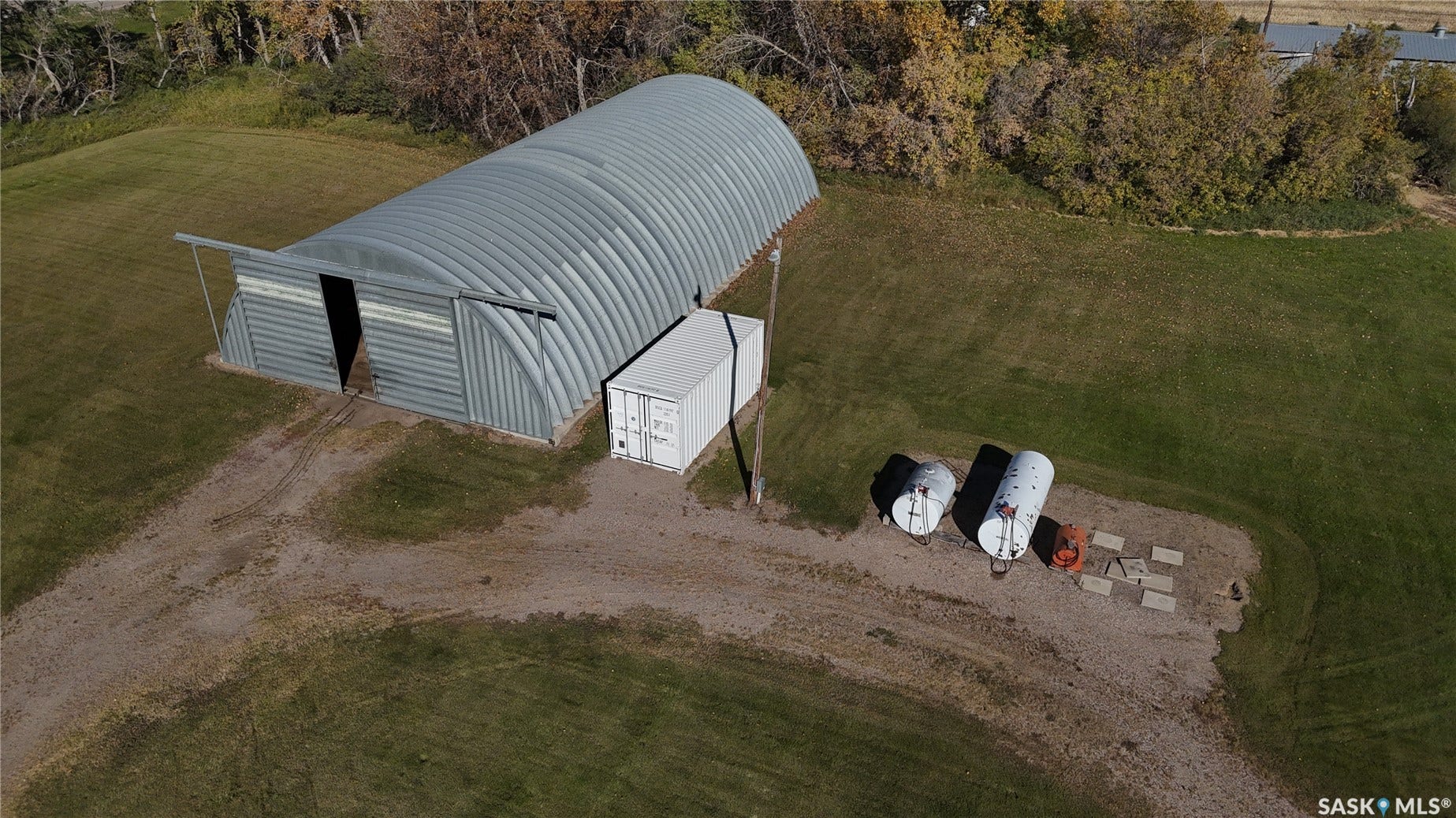 Quonset-style building with a metal exterior, a large entry, and an attached covered area