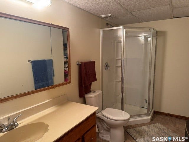 Corner shower enclosure with clear glass panels, single-basin vanity with integrated countertop, wood-finish vanity cabinet, recessed medicine cabinet with wood-finish frame, and overhead vanity lighting