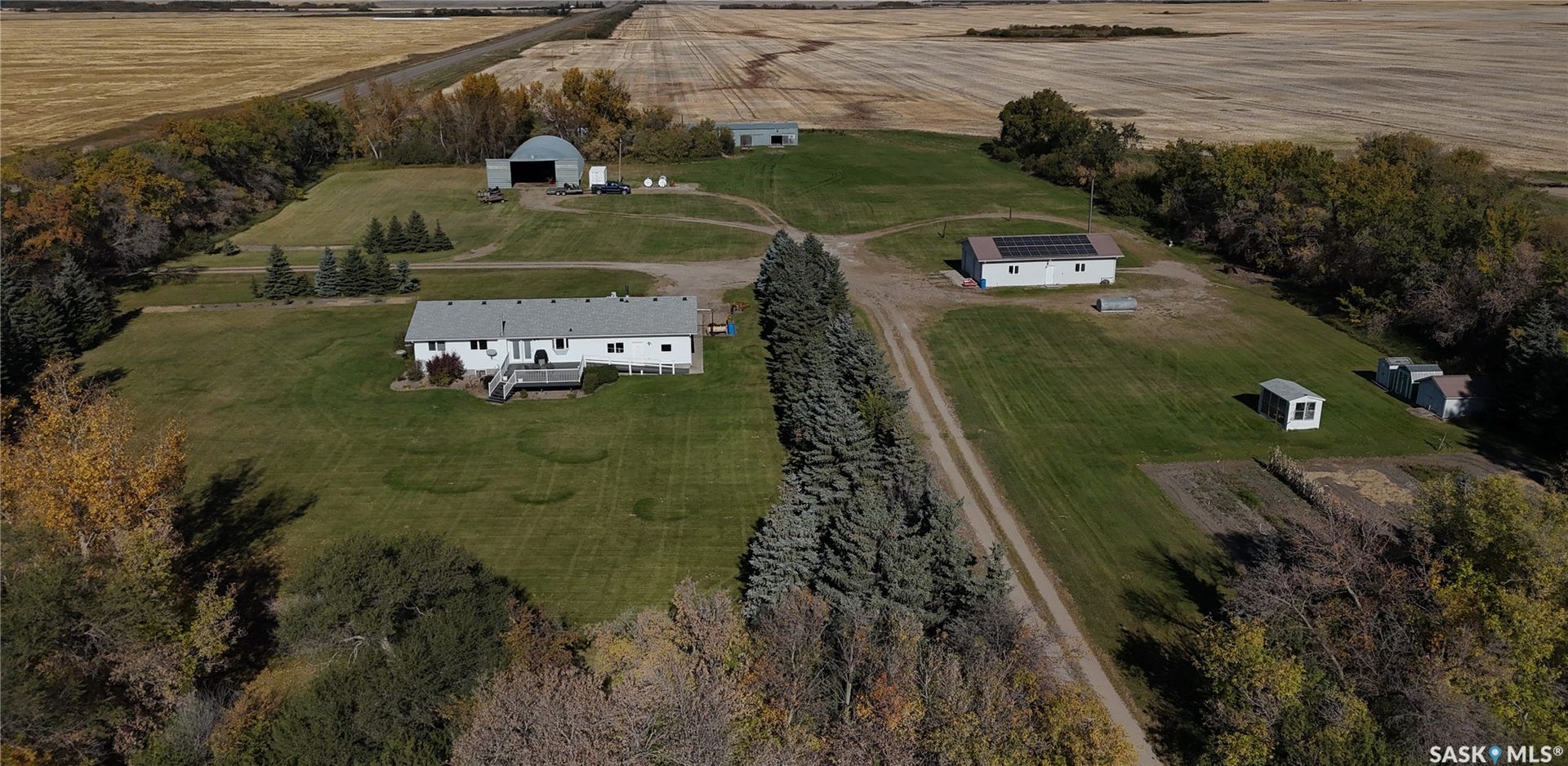 Expansive property featuring a main residence, multiple outbuildings, and cultivated land
