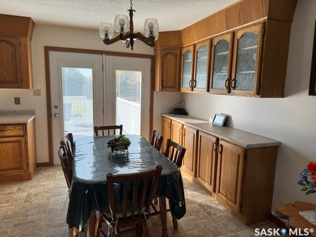 Wood-finish cabinetry with glass-front uppers, laminate countertops, and tile flooring