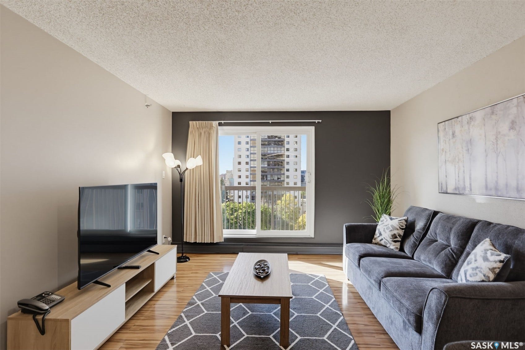 Wood-finish flooring throughout, featuring a sliding glass door with balcony access
