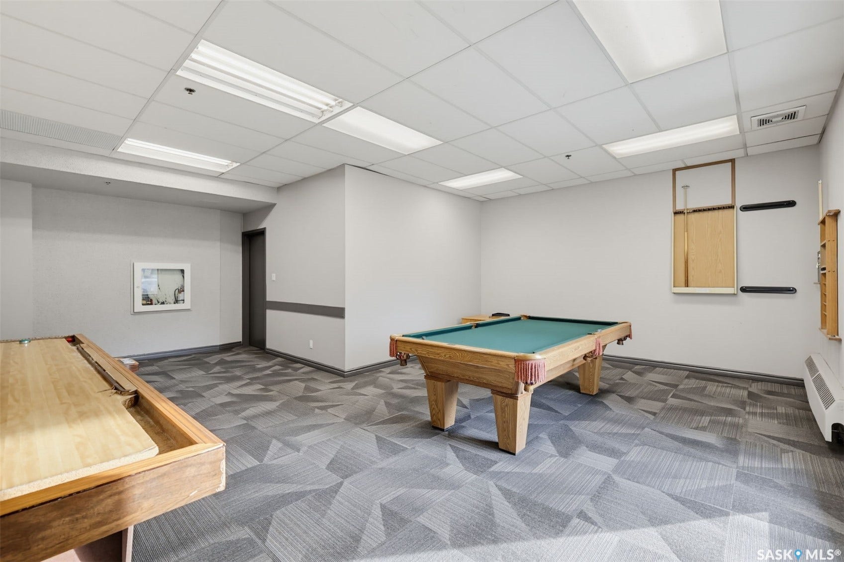 Recreational room featuring a billiard table, shuffleboard table, drop ceiling with integrated lighting, and geometric-patterned carpet