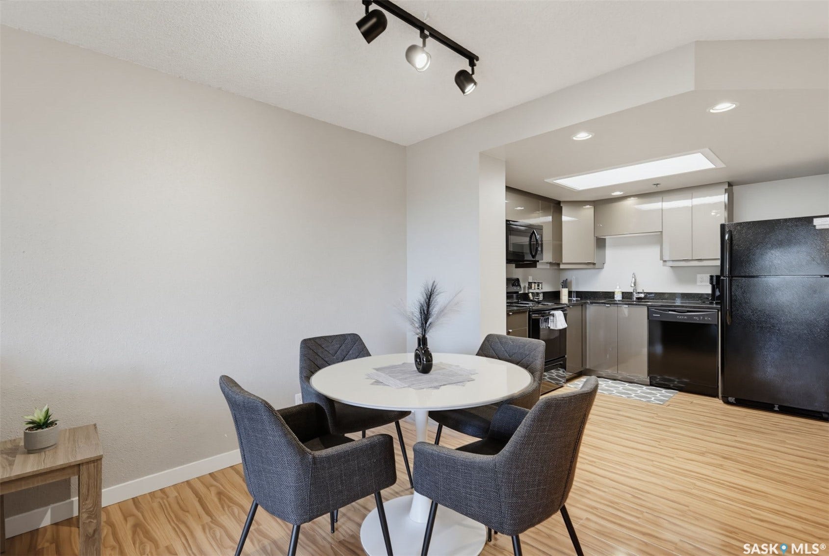 Kitchen with glossy gray cabinetry, black appliances, recessed lighting, and a track light fixture