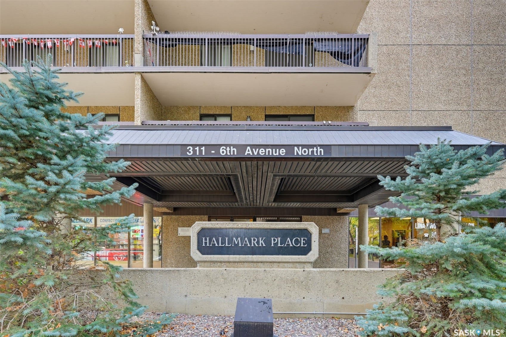 Building entrance with "Hallmark Place" signage, covered entryway, and upper-level balconies