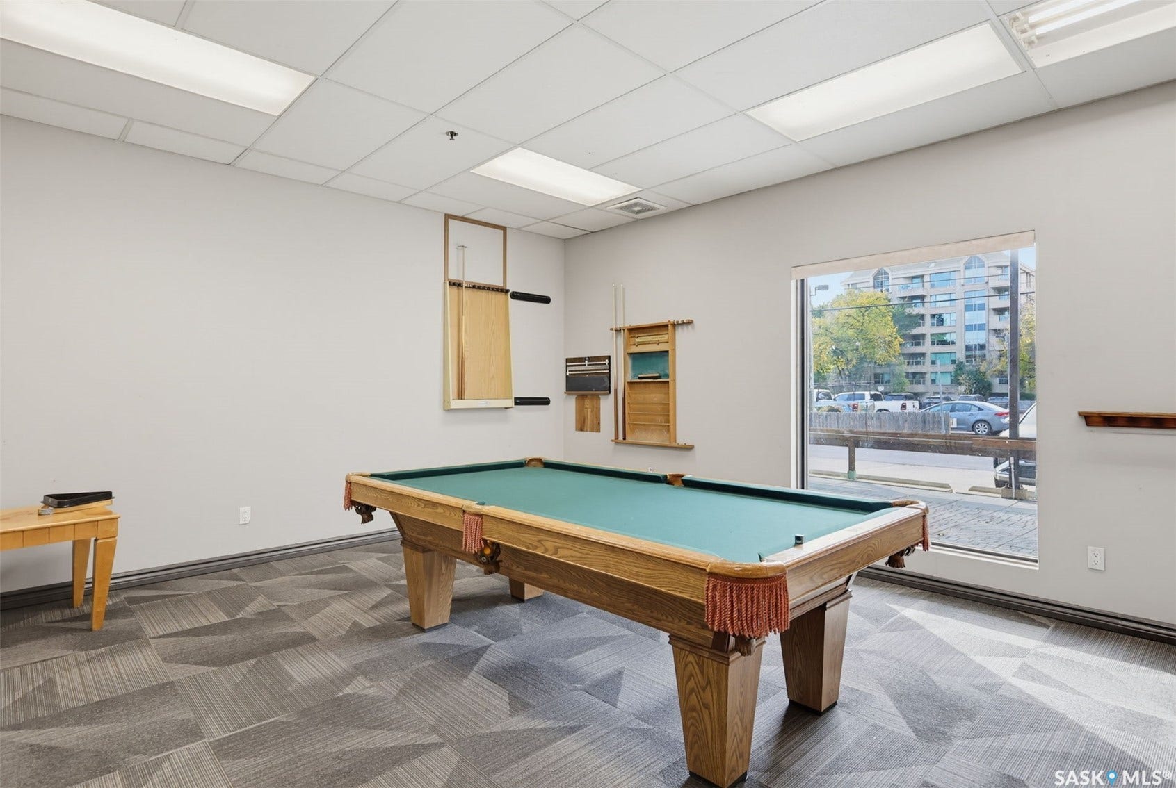 Recreational room featuring a pool table, patterned carpet flooring, and a large window