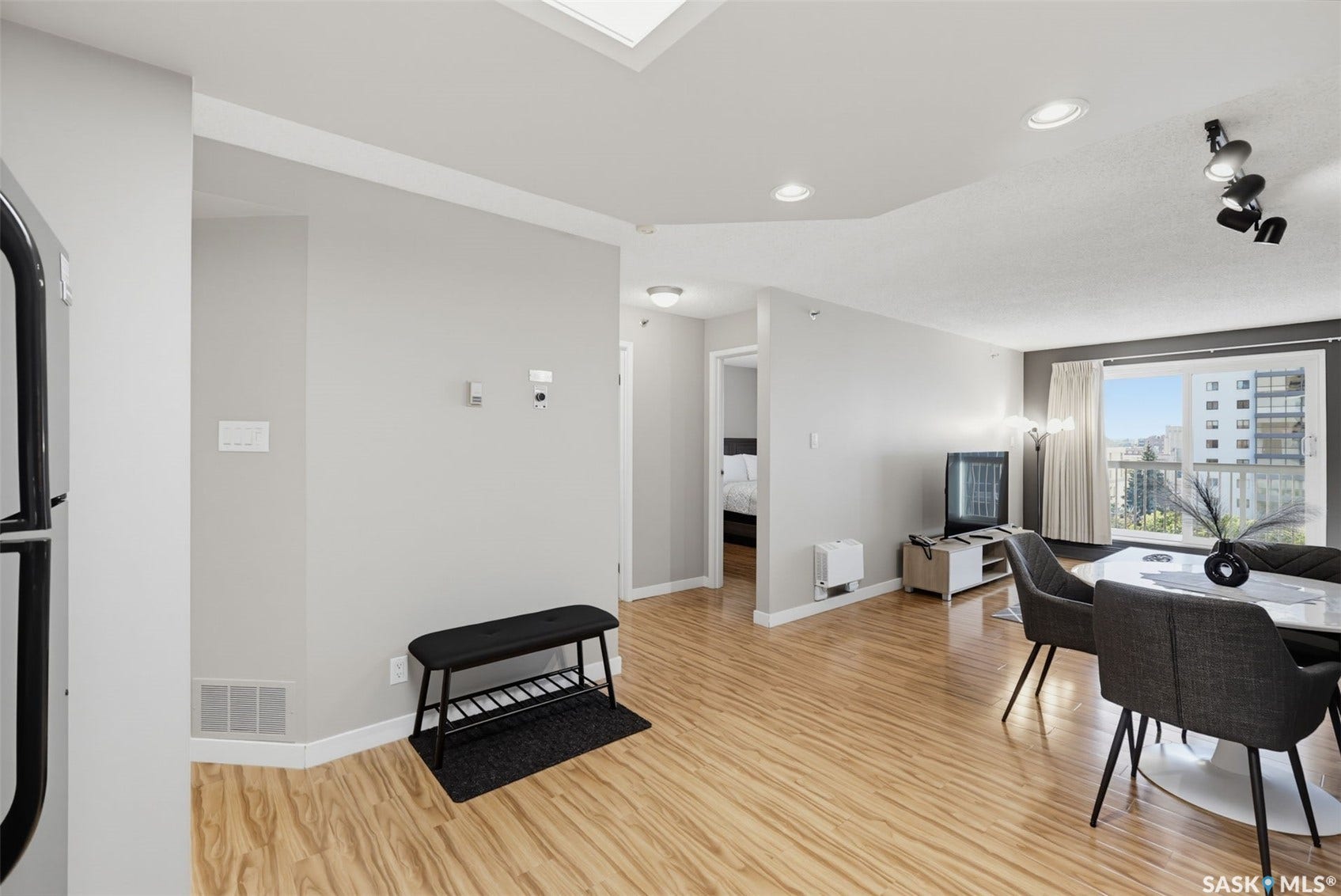 Light wood-finish flooring throughout, recessed ceiling lighting, and a skylight feature