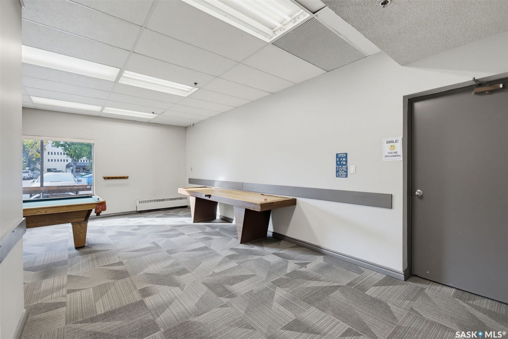 Recessed lighting, drop ceiling, wall-mounted trim, large window, and patterned carpet