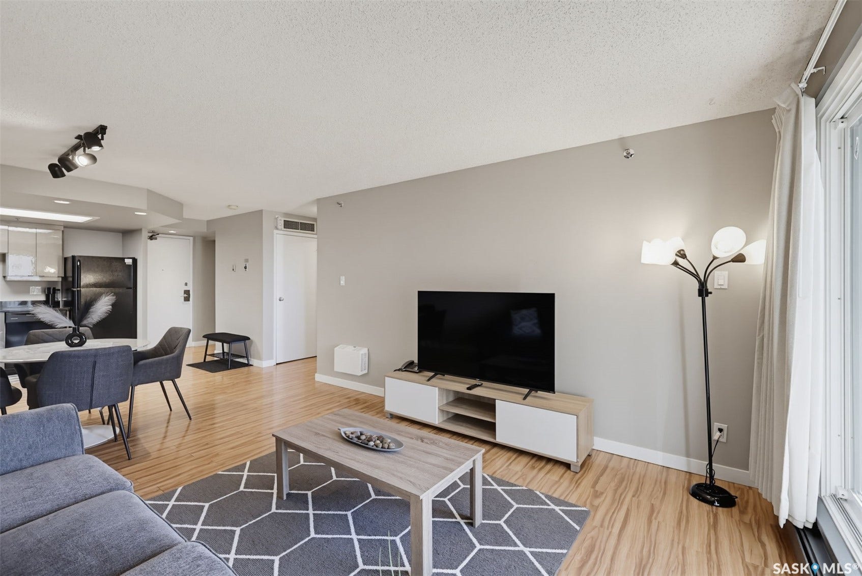 Open-concept living area featuring wood-finish flooring, recessed lighting, and a neutral color palette