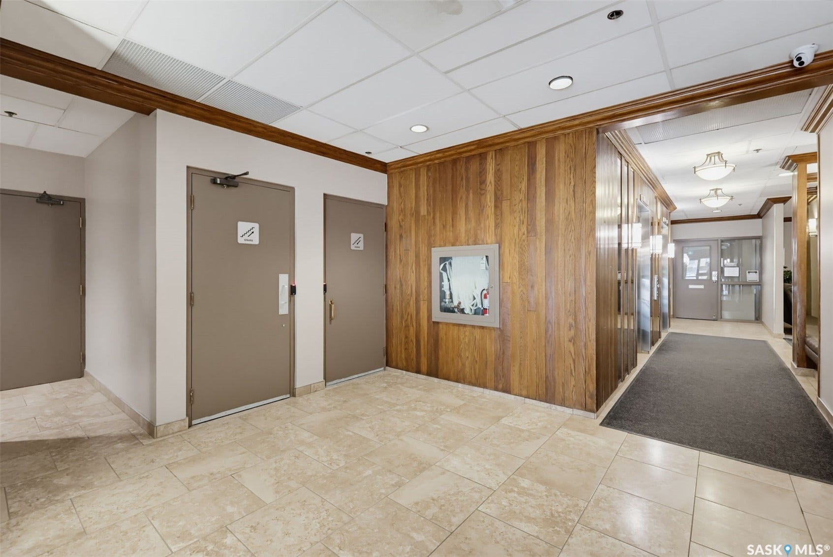 Tile flooring with a matte finish, wood-paneled walls, and decorative ceiling lighting