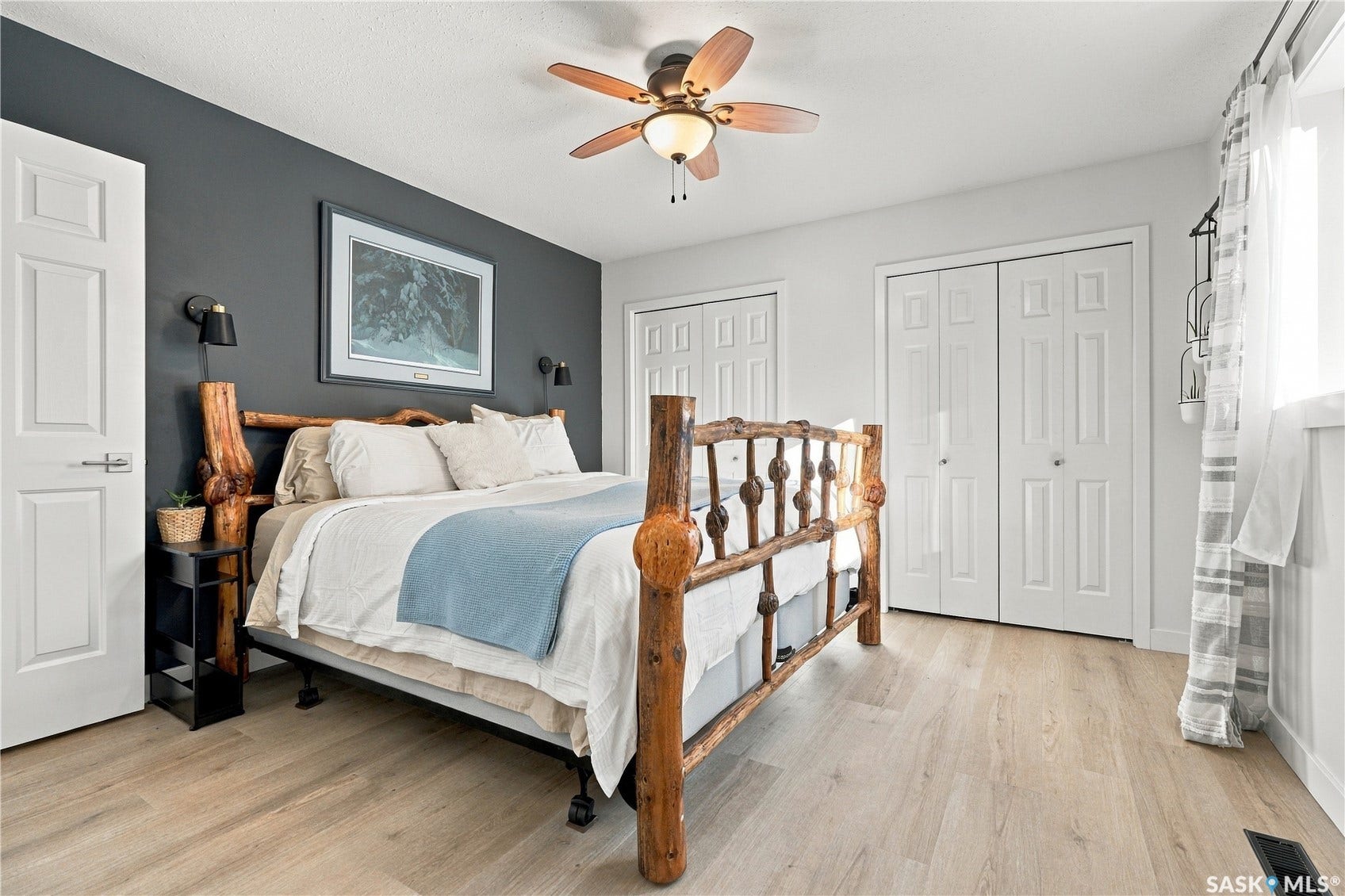 Wood-finish flooring, ceiling fan with light fixture, and panel doors