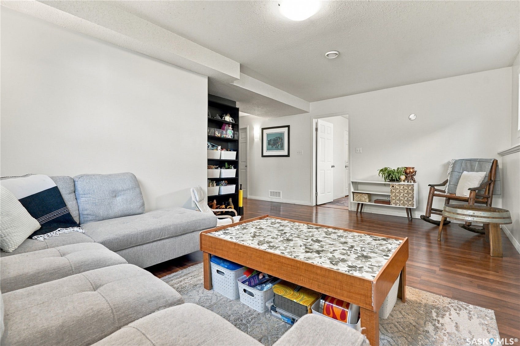 Hardwood-finish flooring, built-in shelving, white walls, and a ceiling-mounted light fixture