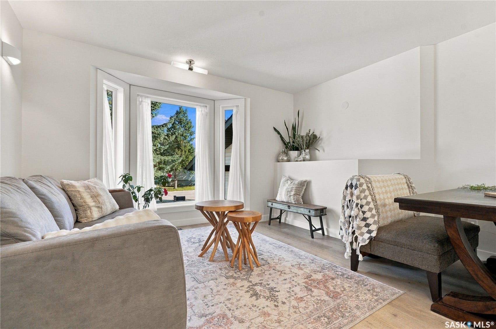 Bay window, light wood-finish flooring, recessed wall niche, wall-mounted lighting fixture, ceiling-mounted lighting fixture